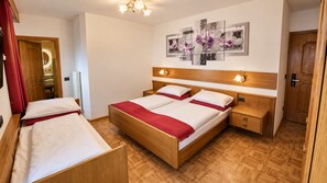 Une chambre d’hôtel avec un lit en bois, une table de chevet, une petite table et une œuvre d’art accrochée au mur.