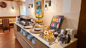 Un buffet proposant une variété de plats, une machine à café et un distributeur de jus de fruits.