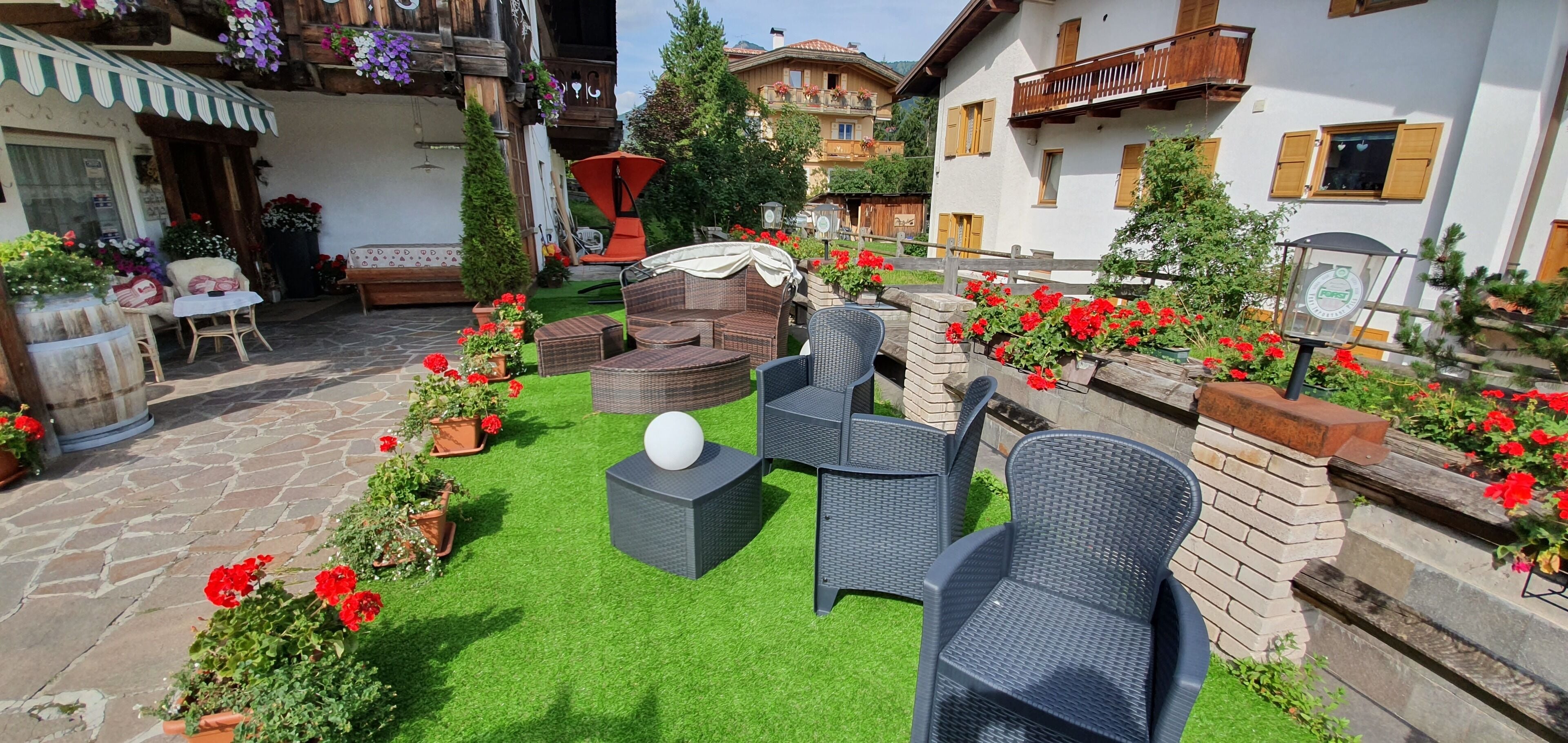 A courtyard with outdoor seating, potted plants, and a stone pathway.