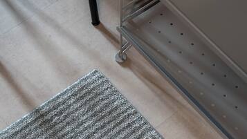 A portion of a room with a grey carpet, a metal filing cabinet, and a chair with a dark seat.
