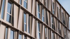 Fachada de edificio moderna con una cuadrícula de ventanas y un diseño geométrico.
