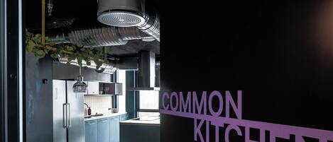 Una cocina moderna con electrodomésticos de acero inoxidable, una zona de bar y una pared con el rótulo