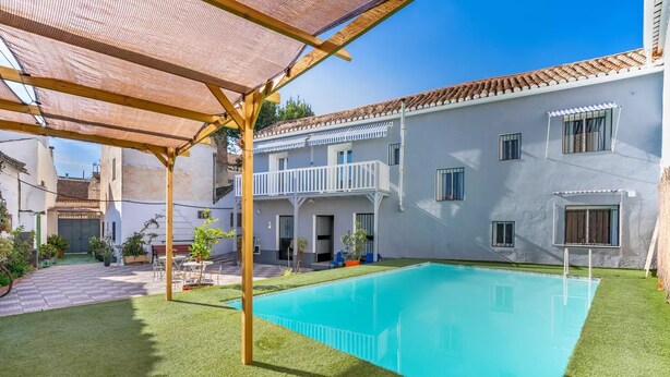 A residential property with a swimming pool, a covered patio, and a two-story building with balconies. - Alojamiento Sierra Nevada Viva.  (Otura)