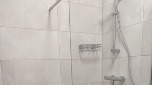 Et moderne bruseområde med glasdør, brusehoved og håndbruser.