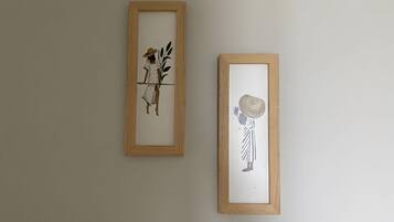 Two framed artworks on a plain wall.