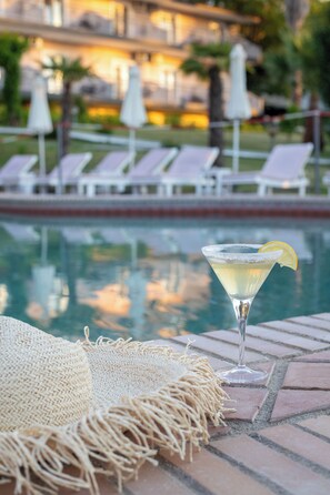 A poolside setting with lounge chairs, a drink, and a woven mat. - Jenny, Siviri (Kassandra)