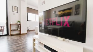 A modern living room with a large flat-screen TV mounted on a white entertainment unit. - ★ Modern studio in City Center, 5min from Beach ★ (Larnaca)