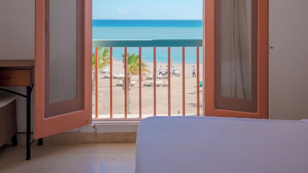 A room with a large window overlooking a beach. - Vesta - El Gouna Residence (El Gouna)