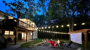 A backyard with a fire pit, outdoor seating, and string lights. - HillTop Manor-Spacious 6BR+PS5+FirePit+Pool Table (Lake,Ariel)