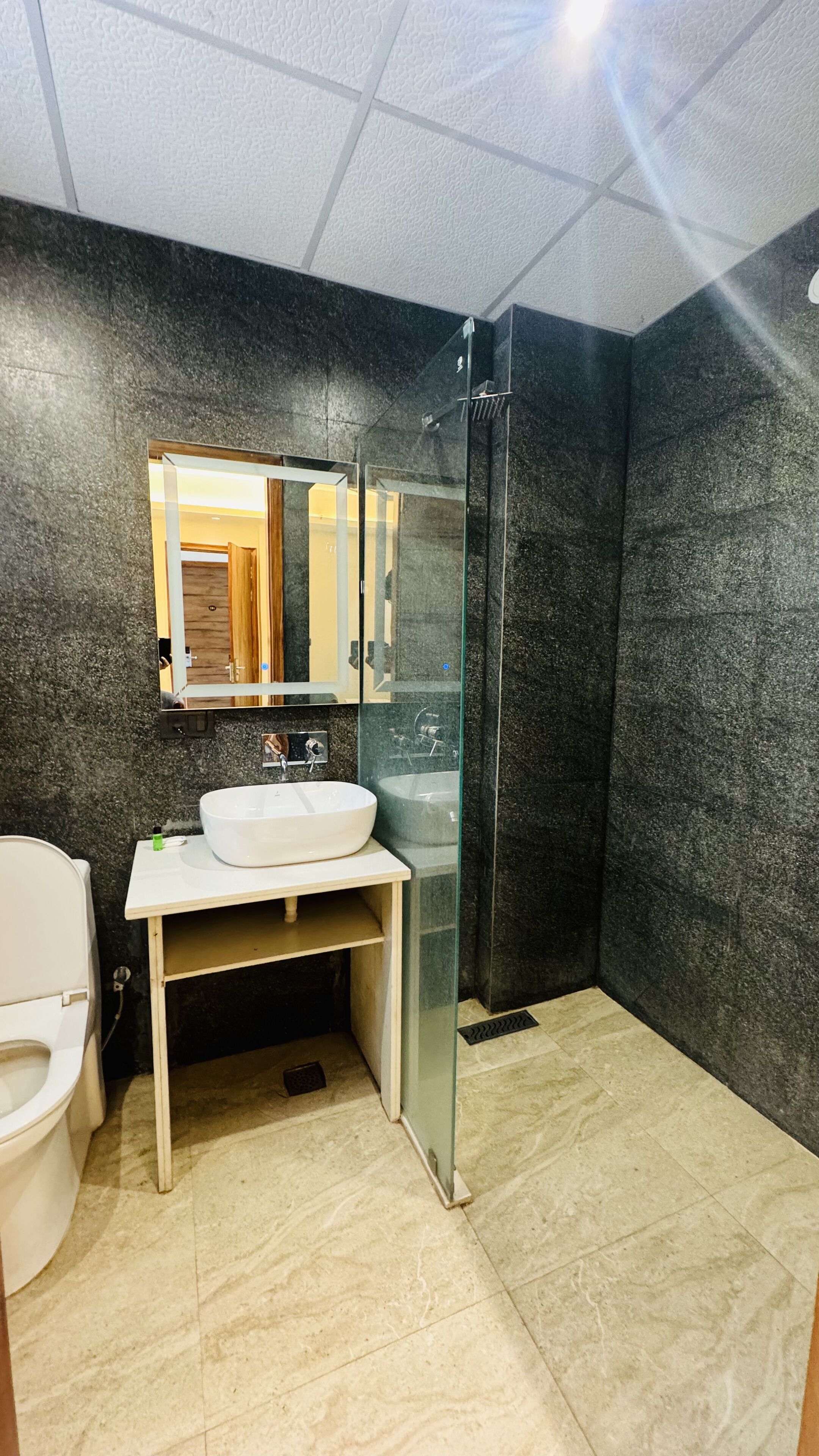 A bathroom with a white sink, a mirror, and a glass-enclosed shower.