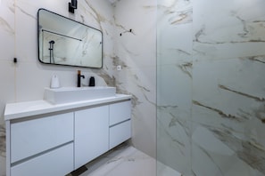 A bathroom with a white vanity, a mirror, and a marble backsplash. - Stunning 2-bed Apartment in Kastela (Kastela)