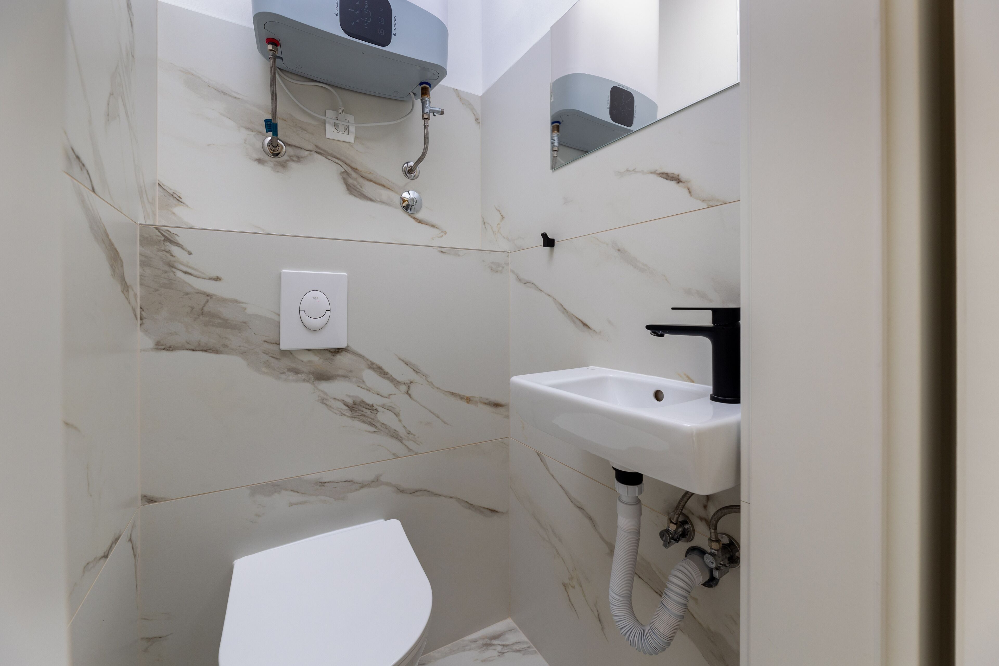 A bathroom with a toilet, sink, and shower.