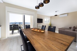 A modern dining area with a wooden table, black chairs, and a view of the outdoors. - Stunning 2-bed Apartment in Kastela (Kastela)
