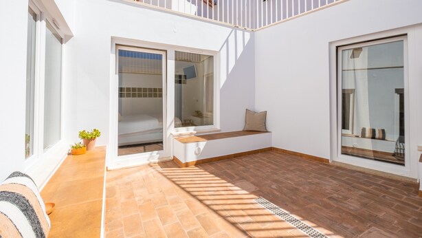 A modern house with a white exterior, a tiled patio, and a balcony with a white railing. - CASASUPERTUBOS ÓBIDOS (Obidos)
