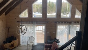 A cozy cabin with a high ceiling, wooden walls, and large windows offering views of a snowy landscape. - Charming chalet with WiFi in Saint-Donat (Saint-Donat)