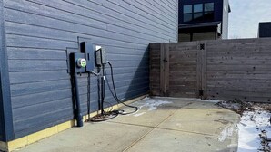 A concrete patio with a blue building and a wooden fence. - Pet-Friendly Carriage House Close to Downtown (Indianapolis)