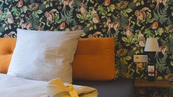 Relax in a serene forest-inspired retreat with a comfortable bed, a nightstand, and a lamp.