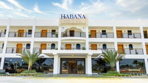 Un hôtel à plusieurs étages, reconnaissable à son grand panneau indiquant « HABANA HOTEL ».