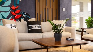 Un salon moderne avec un canapé, une table basse et des coussins décoratifs.