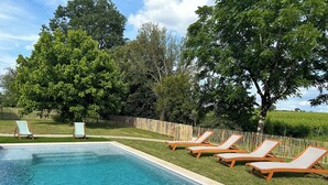 A rectangular swimming pool with clear blue water, surrounded by a wooden deck. There are six lounge chairs aligned along the poolside. - Charming cottage with swimming pool in the heart of the Monbazillac vineyard (Monbazillac)