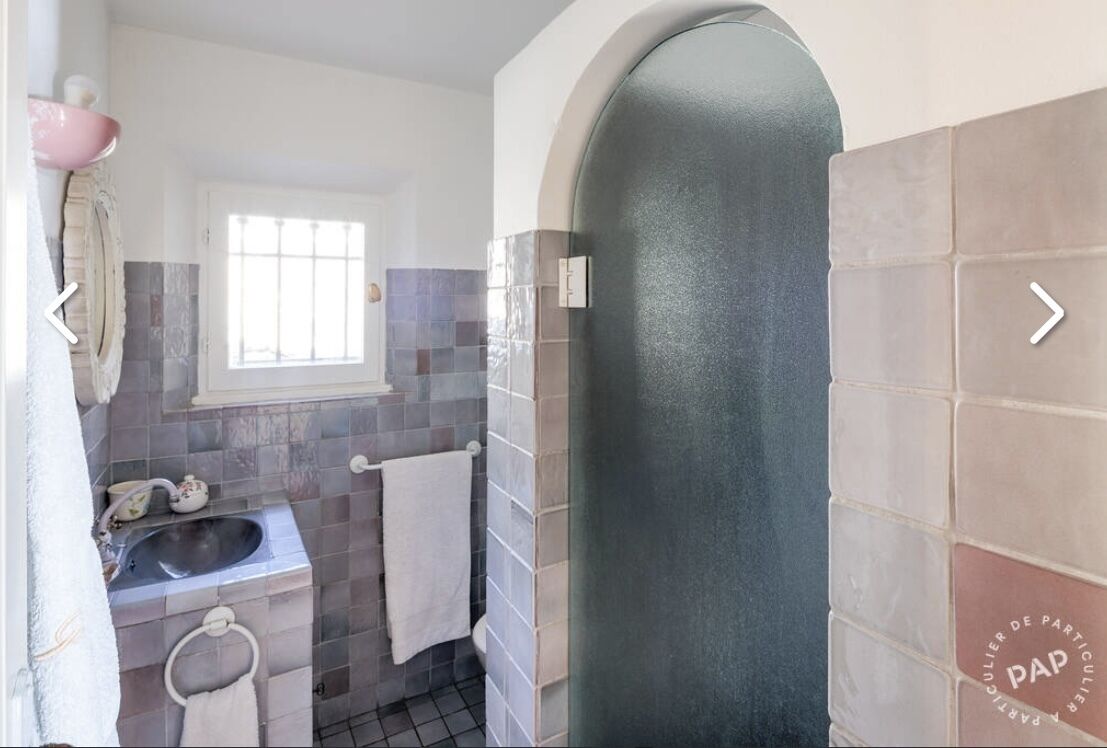 A bathroom with a sink, a mirror, and a window.