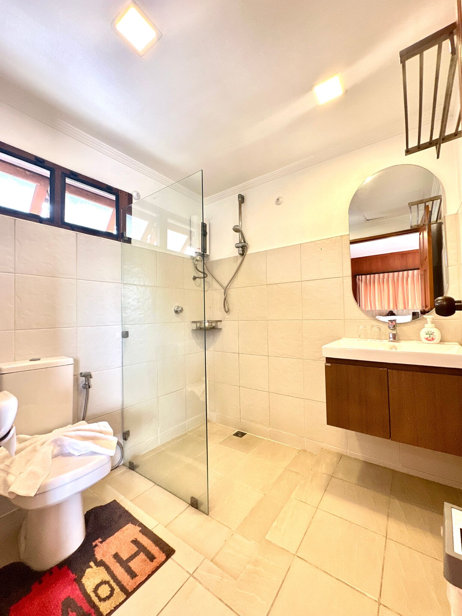 Une salle de bain moderne avec une douche à parois de verre, des toilettes et un meuble-lavabo avec un miroir.