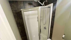 A bathroom with a shower, toilet, and sink. - Central Farmhouse-Style Micro Apartment (Lethbridge)