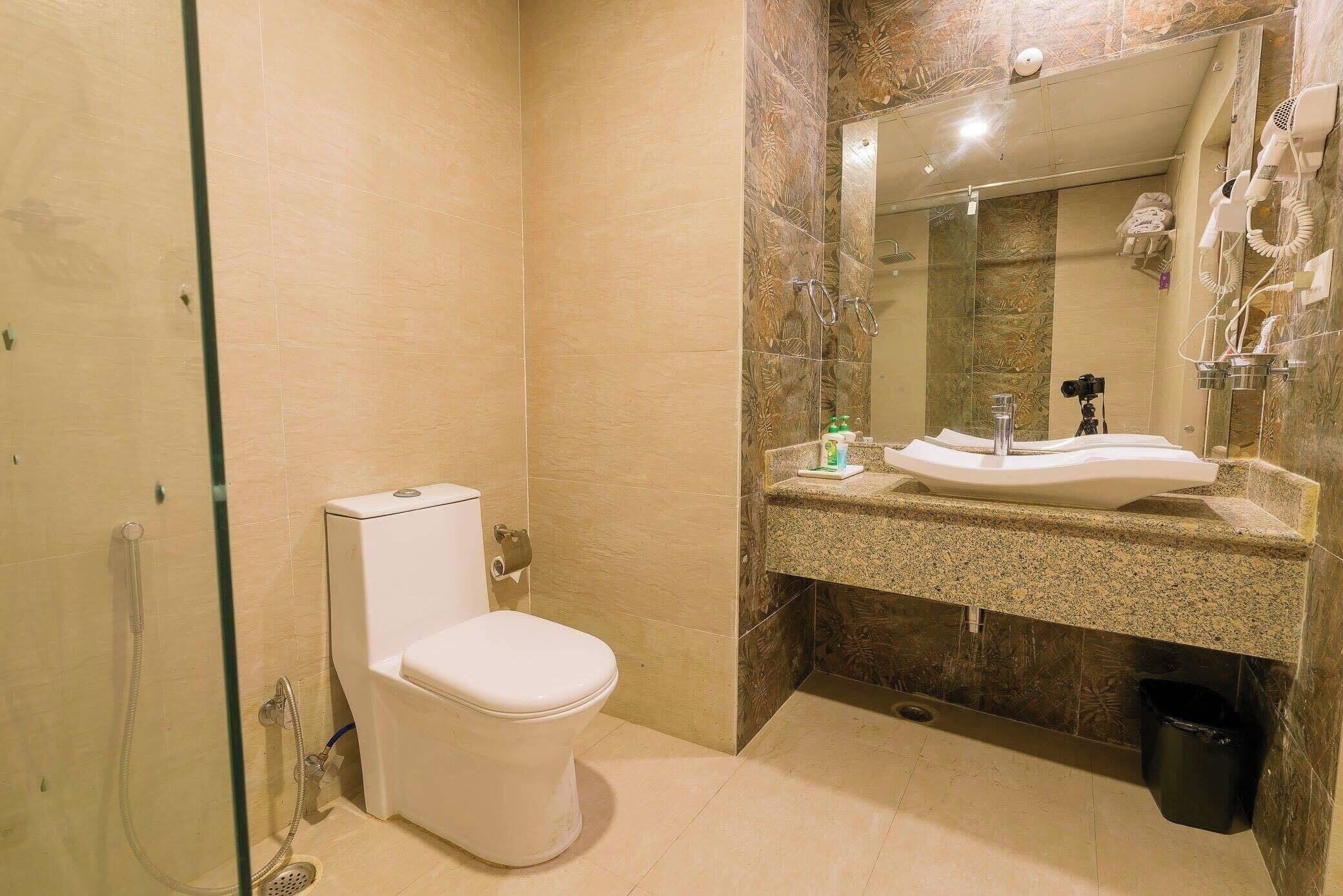 Un baño moderno con inodoro, lavamanos y ducha.