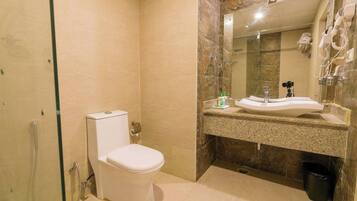 Un baño moderno con inodoro, lavamanos y ducha.