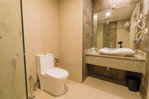 Un baño moderno con inodoro, lavamanos y ducha.