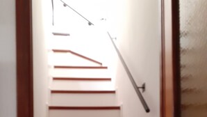 A staircase with wooden steps and a handrail, leading to an upper floor. - CasaRina Poggi - 360° Panoramic Terrace from the Mountains to the Sea and Relaxation in Imperia (Poggi)