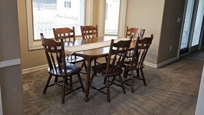 A dining area with a wooden table and chairs, large windows, and a chandelier. - 3 bedroom, 2.5 bath home,  with 2 car garage, minutes from Frankenmuth.  (Birch Run)