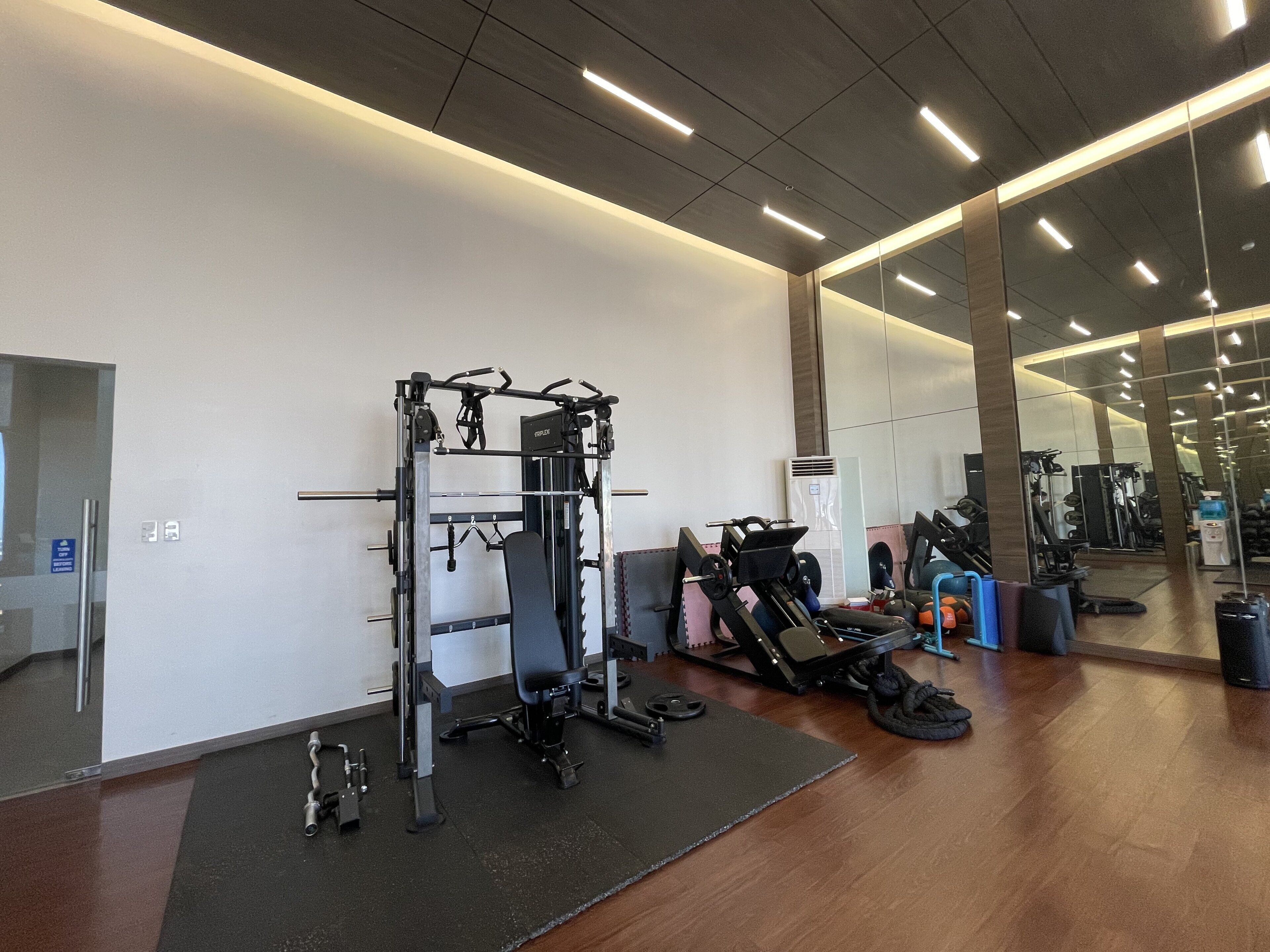 A gym with a pull-up bar, weight bench, and various exercise equipment.