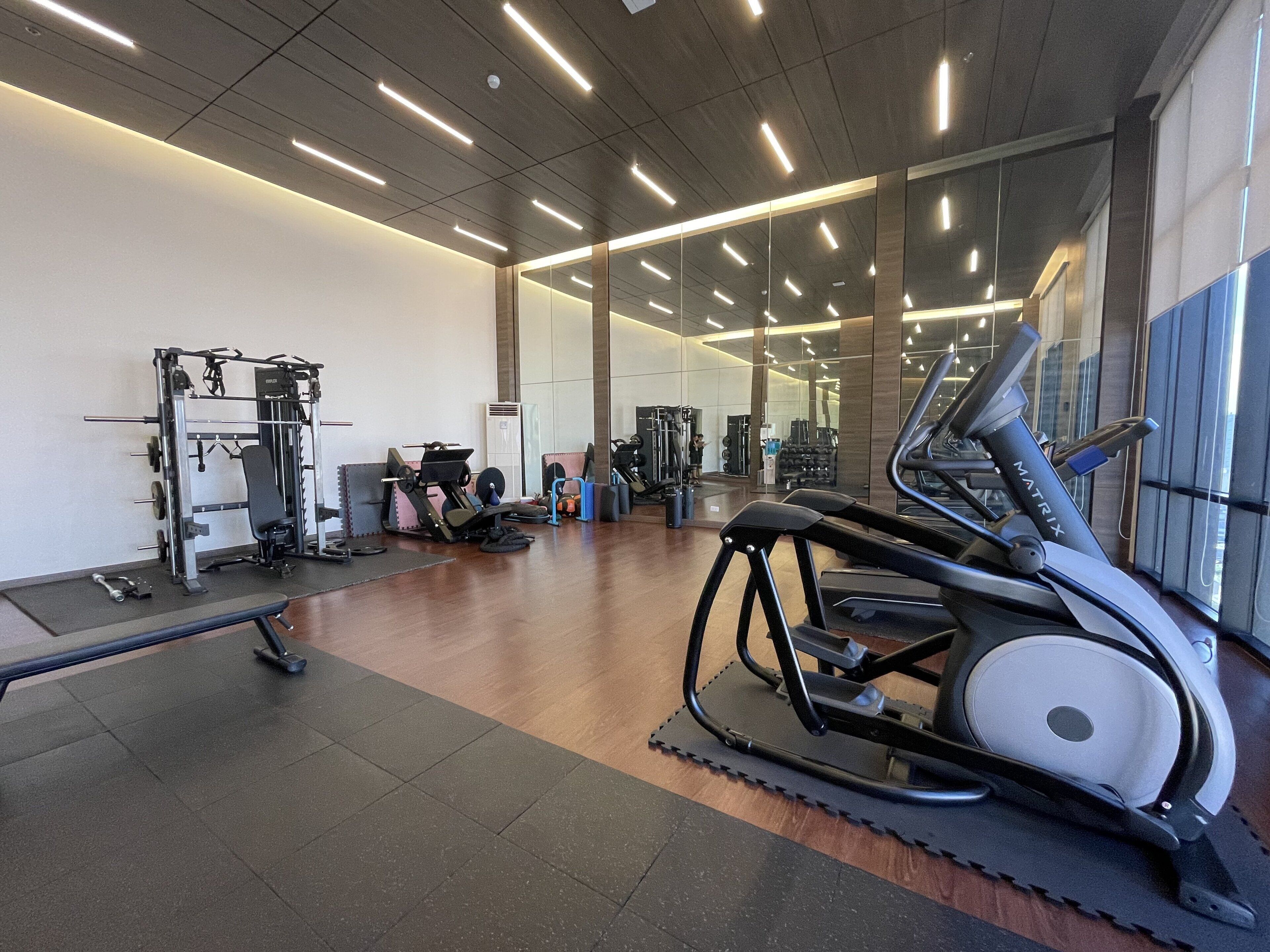 A gym with various exercise equipment, including a treadmill, weight machines, and free weights.