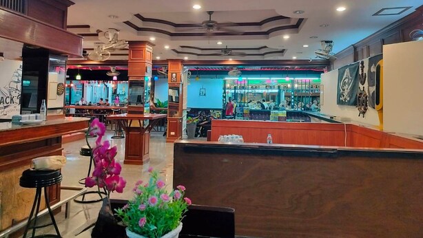 A restaurant with a bar area, wooden decor, and a ceiling with recessed lighting. - Seascape (Patong)