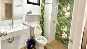 A bathroom with a sink, toilet, and shower.