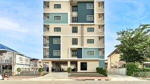 A multi-story hotel with a modern design, featuring a prominent entrance with steps and a sign above the door.
