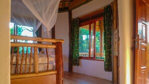 A room with a wooden bed, a window with green curtains, and a wooden door. - Lake Nkuruba Nature Reserve (Fort Portal)