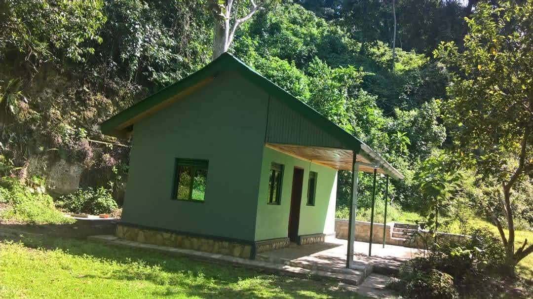 A small, single-story building with a green roof and a covered porch area.