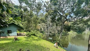 A house with a grassy yard and a pond. - Lake Nkuruba Nature Reserve (Fort Portal)