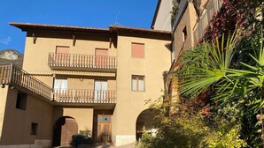 Un bâtiment doté d’une entrée centrale, de deux balcons et d’une cour pavée.