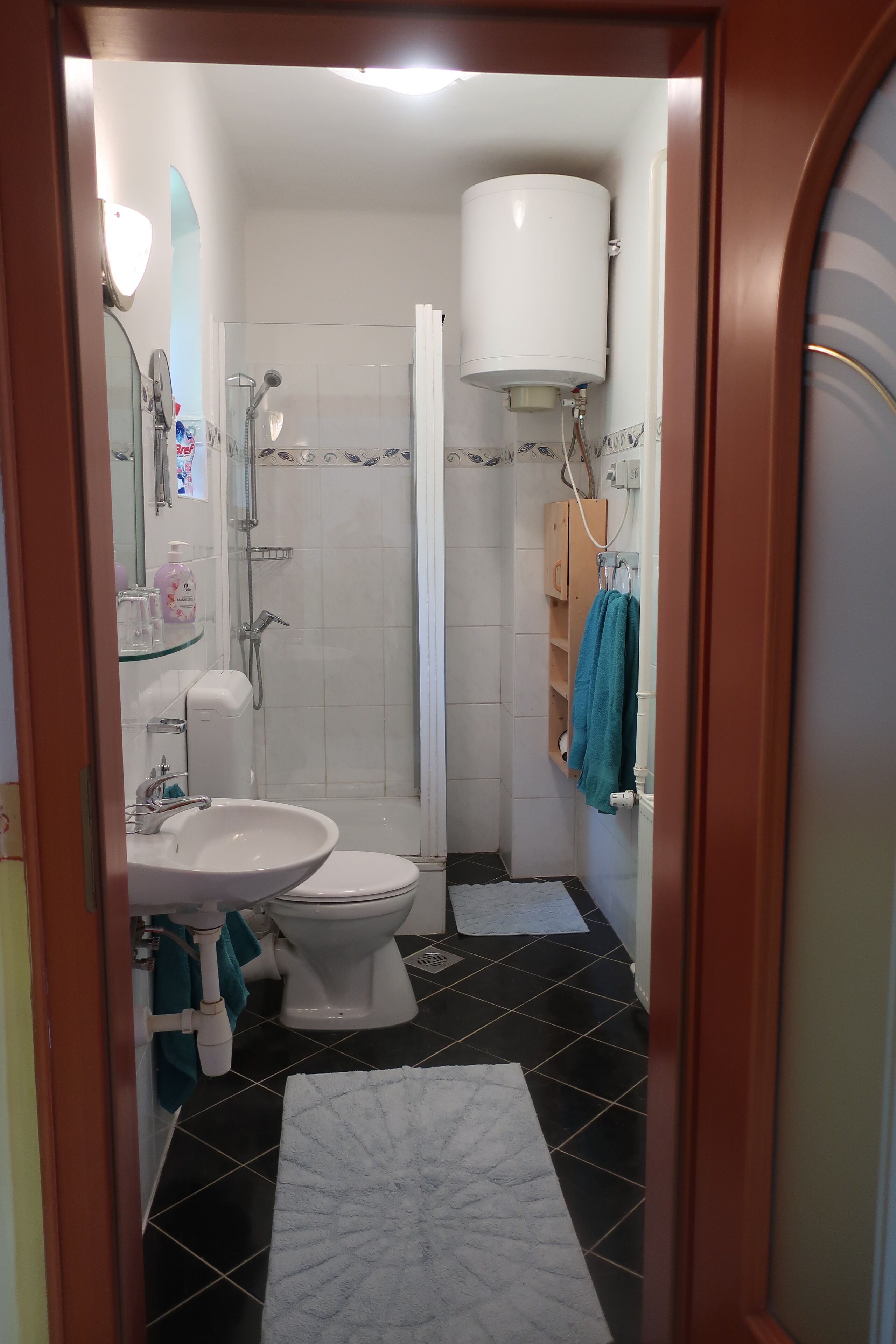 A bathroom with a toilet, sink, and shower.