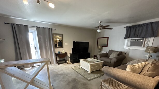 A living room with a sofa, coffee table, and a TV. - Cozy studio cottage in enchanting Lake Charles with AC, WiFi.   (Lake Charles)