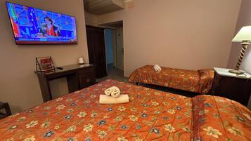 Una habitación de hotel con dos camas, un escritorio, un televisor y una lámpara.