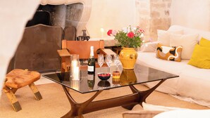 Un soggiorno moderno con un tavolino in vetro, un divano e un vaso decorativo con fiori.