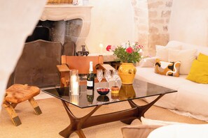 Ein modernes Wohnzimmer mit einem Glastisch, einer Couch und einer dekorativen Vase mit Blumen.