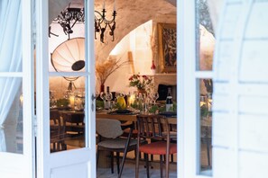 An interior dining area with tables set for a meal, chairs, and a chandelier. - Beautiful Bastide in Provence with swimming pool, tennis court, and jacuzzi (CERESTE EN LUBERON)