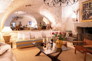 A cozy interior with a sofa, a glass coffee table, and a fireplace. - Beautiful Bastide in Provence with swimming pool, tennis court, and jacuzzi (CERESTE EN LUBERON)
