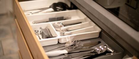 A drawer with utensils and kitchenware.