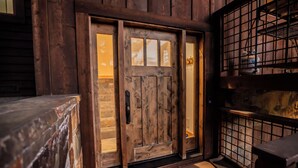 Una puerta de madera con un panel de vidrio y una reja de metal en el lado derecho.